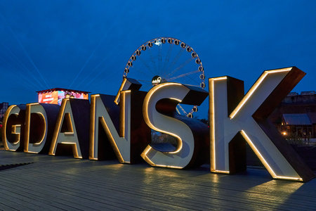 ferris wheel and historic buildings with illuminated city sign on the Motlawa River in the Old Town of Gdansk in Pomerania, Poland.の写真素材