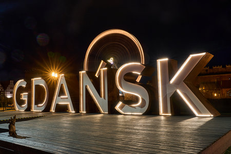 ferris wheel and historic buildings with illuminated city sign on the Motlawa River in the Old Town of Gdansk in Pomerania, Poland.の写真素材