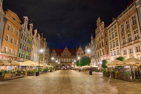 Cityscape of the historic old town in the center of Gdansk in Poland with ancient buildings with reflections of illuminated buildings on the water of Motlawa river.の写真素材