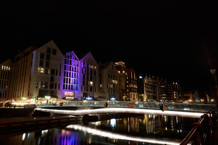 Cityscape of the historic old town in the center of Gdansk, Danzig in Poland with ancient buildings with reflections of illuminated buildings on the water of Motlawa river.の写真素材