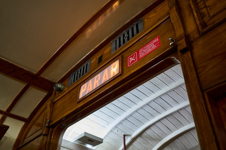 wooden interior of a typical old vintage tram on the streets of Lisbon old town at night, illuminated signs by lights in Portugal.の写真素材