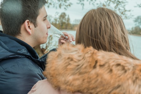 A young couple sits relaxing on a riverの写真素材