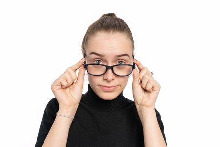 a young woman holds down the glasses and looks over the glasses