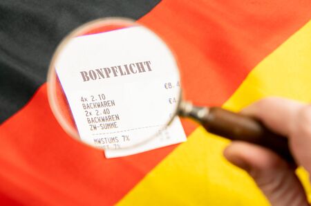 A receipt with the German inscription receipt obligation on a German flagの写真素材
