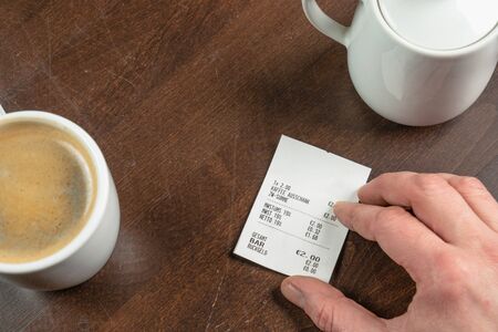 a hand hold a receipt on a wooden tableの写真素材