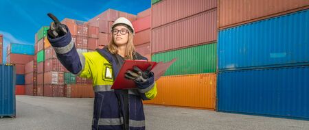 A female docker in protective gear in a container handling areaの写真素材