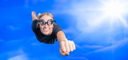 a concept image of a young strong woman flying with a clenched fistの写真素材