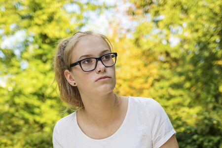 Young girl is sitting in the park and think about lifeの写真素材