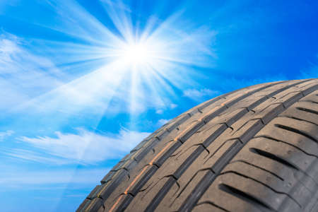 a detail photo of a car tire profile with sky in backgroundの写真素材