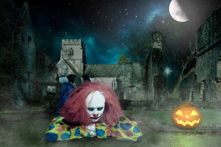 a bored clown in a spooky setting with a pumpkin and an old wallの写真素材
