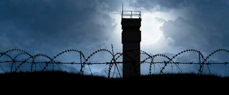 a watchtower behind barbed wire as a symbol of division