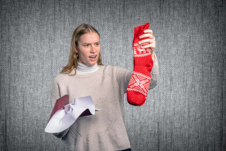 a disappointed young woman holds her gift upの写真素材