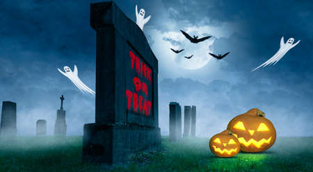 a creepy halloween with trick or treat text on a tombstoneの写真素材