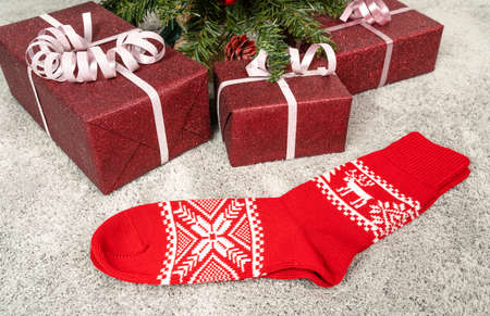 a pair of red Christmas socks under a Christmas treeの写真素材