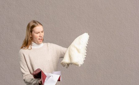 a young woman holds up her present she is disappointed