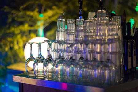 Glasses of champagne on bar counter with barman professional, which making cocktail drinks in background, soft focusの写真素材