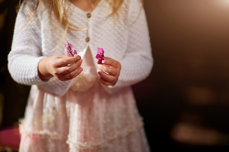 child, hands close-up, flowers, white sweater a solar flareの写真素材