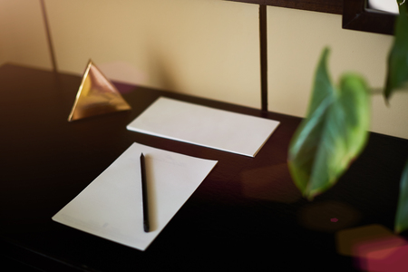 Blank notebook and smartphone with pencil on Laptop and wooden table. The view from the topの写真素材