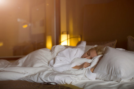 young girl in a white robe lying on the bed