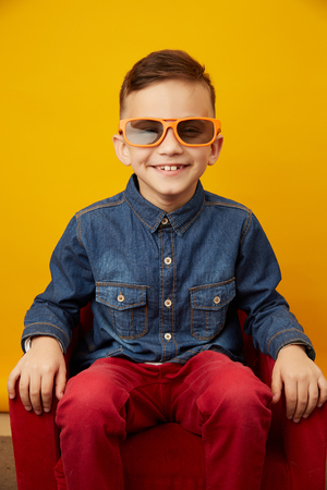 Boy 8 years old in denim shirt red pants and 3d dadget technologyの写真素材