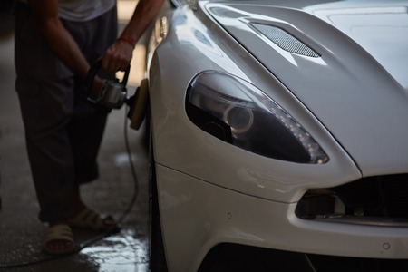 Car polishing series : Worker waxing white car doorの写真素材
