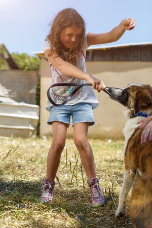 Beautiful Little girl hugging retriever in the summer parkのeditorial素材