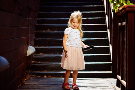 Blonde on a wooden staircase enjoying summer vacationの写真素材