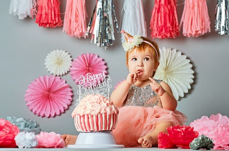 Cute baby tasting the birthday cakeの写真素材