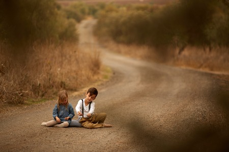 Brother and sister Autumn roadの写真素材