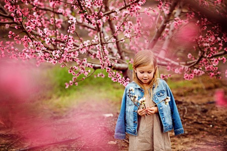 little girl in wild flowers wreath walking on road barefootの写真素材