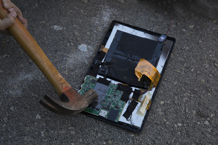 Hammer and smartphone. The screen of the smartphone, a broken hammer. The destruction of the phone.の写真素材