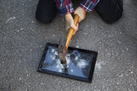 Hammer and smartphone. The screen of the smartphone, a broken hammer. The destruction of the phone.の写真素材