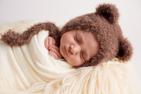New born Baby girl sleeping with her teddy bearの写真素材