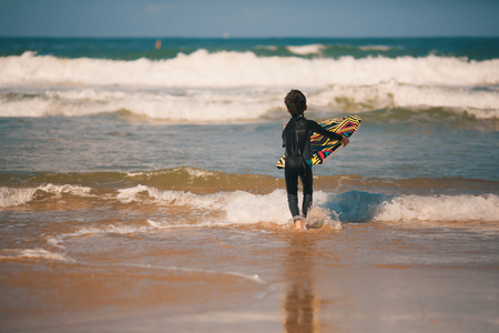 Young surfer, happy young boy in the ocean on surfboardの写真素材