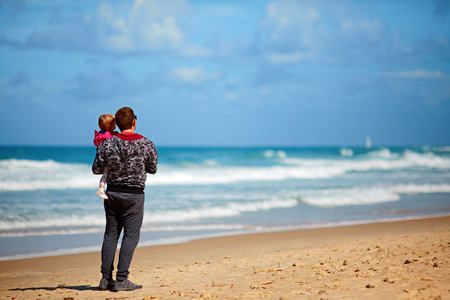 father and daughter walking on the beachの写真素材