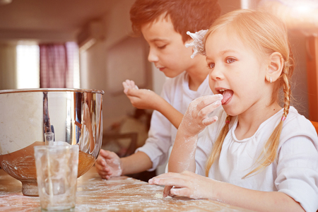 Children play with flour prepare dough.の写真素材