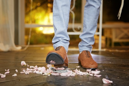Groom breaking a glass at a Jewish wedding stamping it underfoot symbolizing the destruction of the temple in Jerusalem, close up of the right footの写真素材