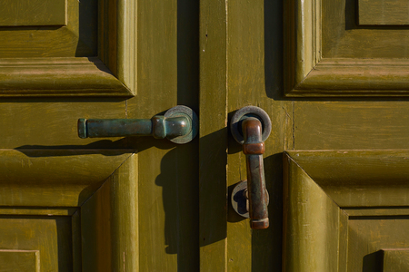 Old green door close-up with handle. Door handle. Old cracked green color. Old wooden door. Damage to colorの写真素材