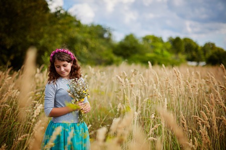 little girl on a wheat field in the sunlightの写真素材