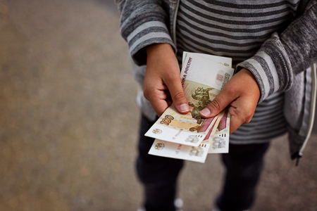 A boy considers Russian money, notes on 100 rubles.の写真素材