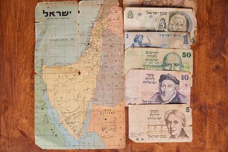Map of the cease - fire in June 1967 and old israeli money on a wooden table.のeditorial素材