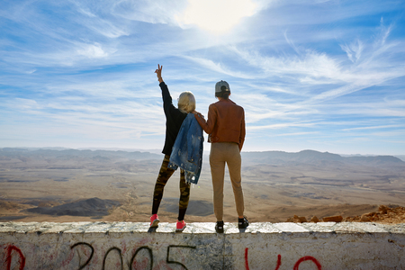 Israel, Negev desert January 13 The back of two women, stand with their hands up overlooking the mountainsのeditorial素材