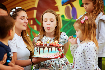 April 1, 2019, Tel Aviv girl blows out the candles on the cake in the family circle, cheerful atmosphere Mom dad daughter and sweet cakeのeditorial素材