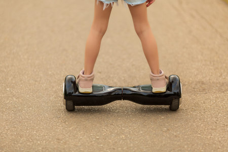 girl rides a giroskuter in the summer on the square
