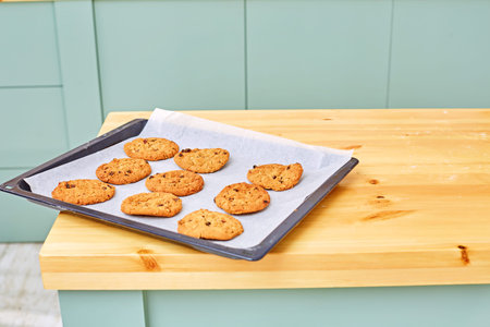 Australian oatmeal cookies close-up on a baking sheet on the table. Chocolate chip cookies on a...
