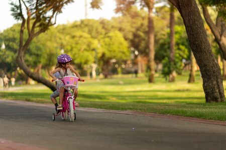 children ride the same bike together in the parkの写真素材