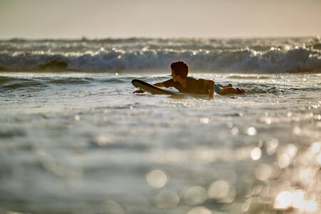 Portrait of boy surfboarding on seaの写真素材