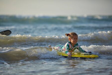 girl with his bodyboard walking into the oceanの写真素材
