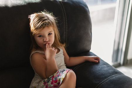 Beautiful child bites his fingers in his mouth