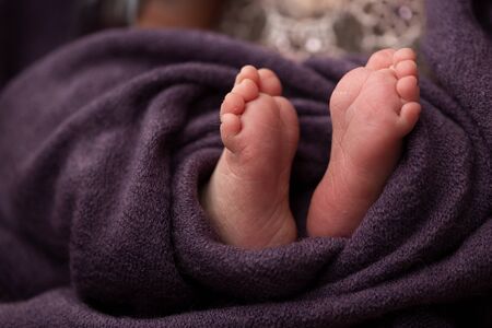 feet of a newborn baby on a purple background. selective focusの写真素材